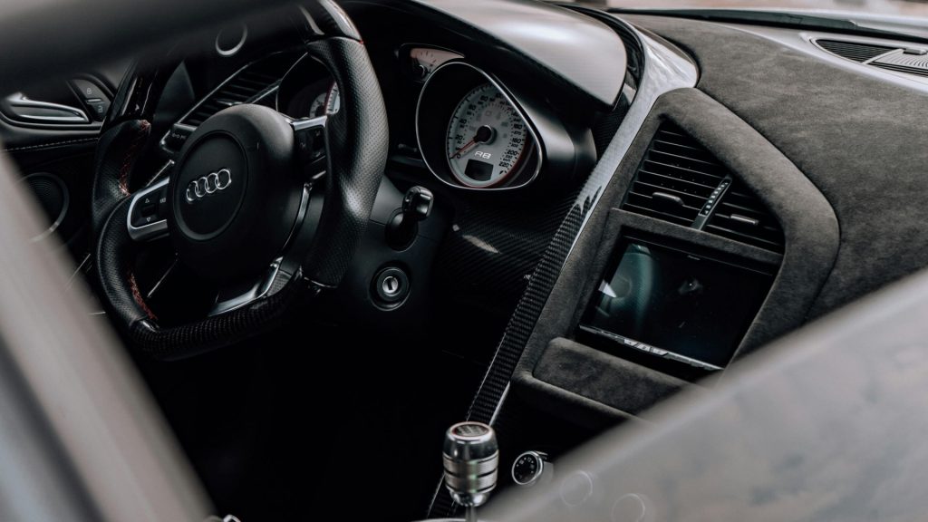 Interior dashboard and steering wheel of an Audi R8 showing premium sports design